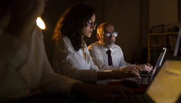 2 people looking at a laptop screen